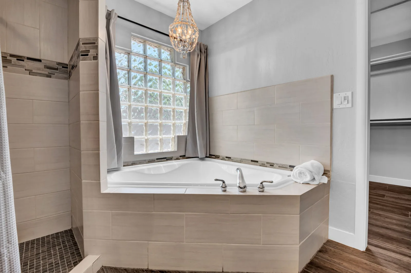 Soaking tub under a glass block window in the primary bath.