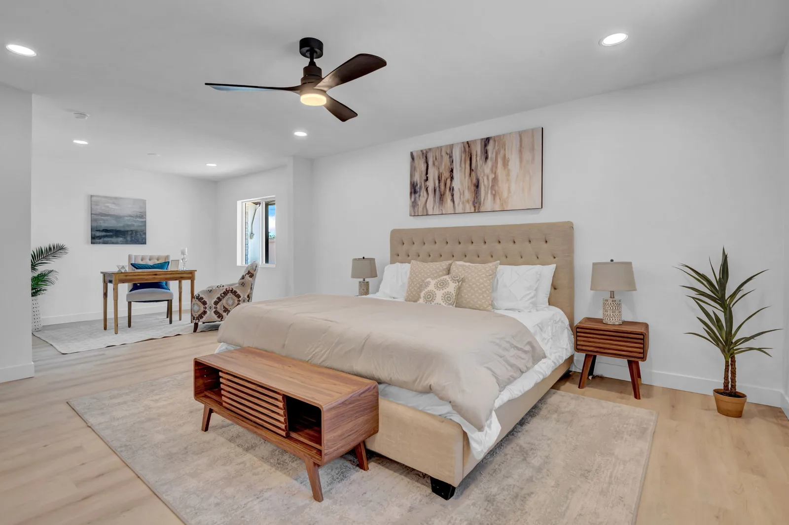 Bedroom with wood nightstands, neutral rug and a slider to the back yard.