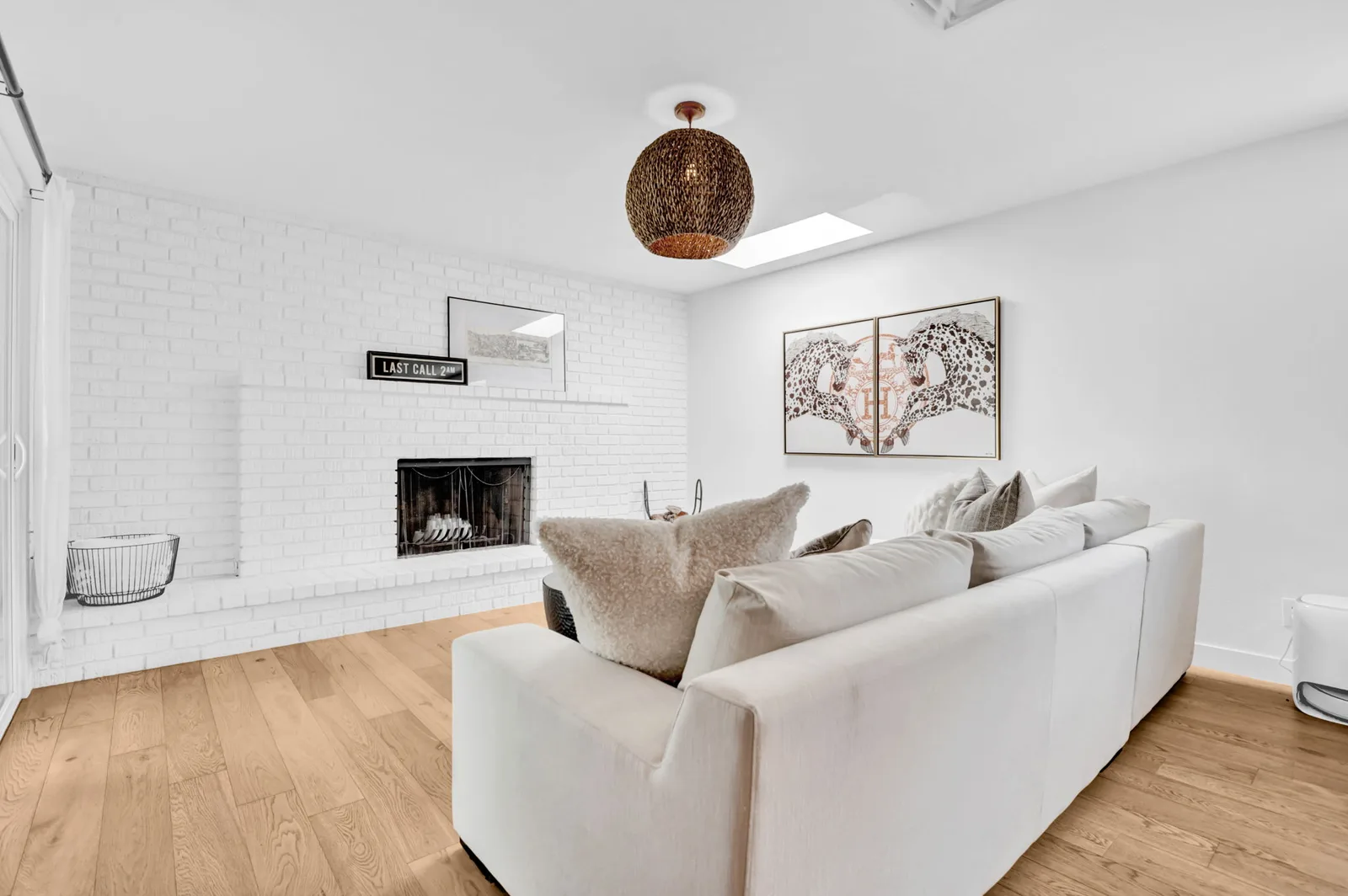 White painted brick fireplace and living room seating.