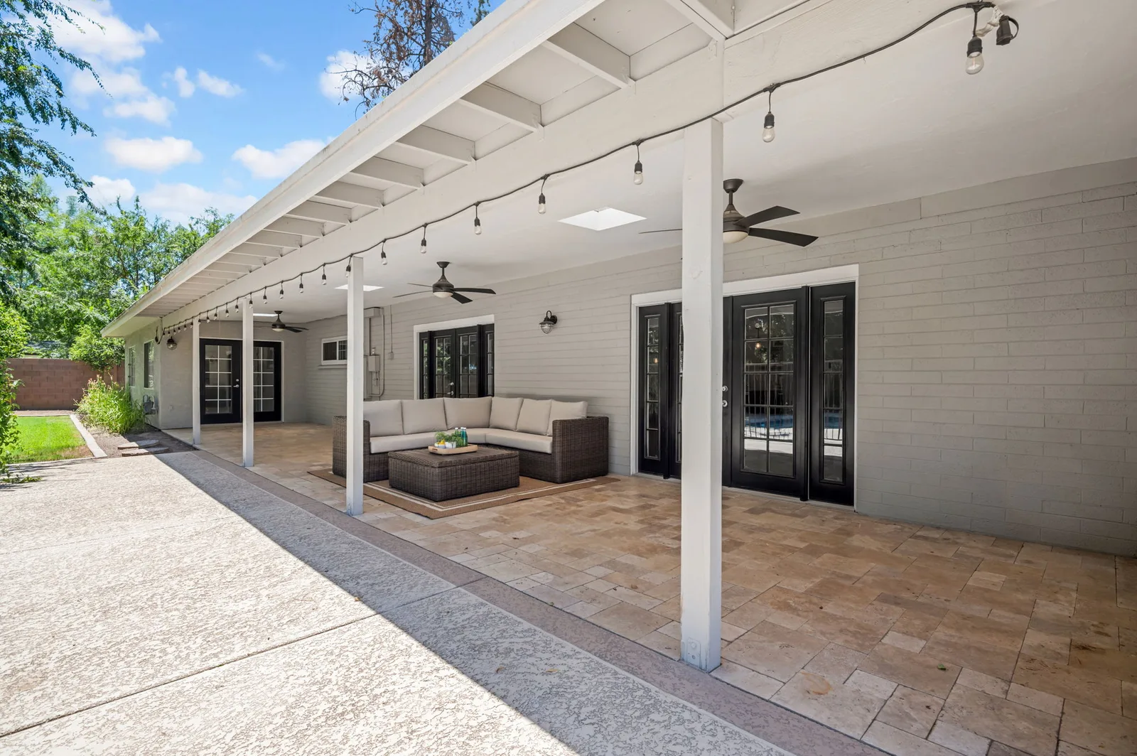 Long covered patio with string lights running the length of the house.