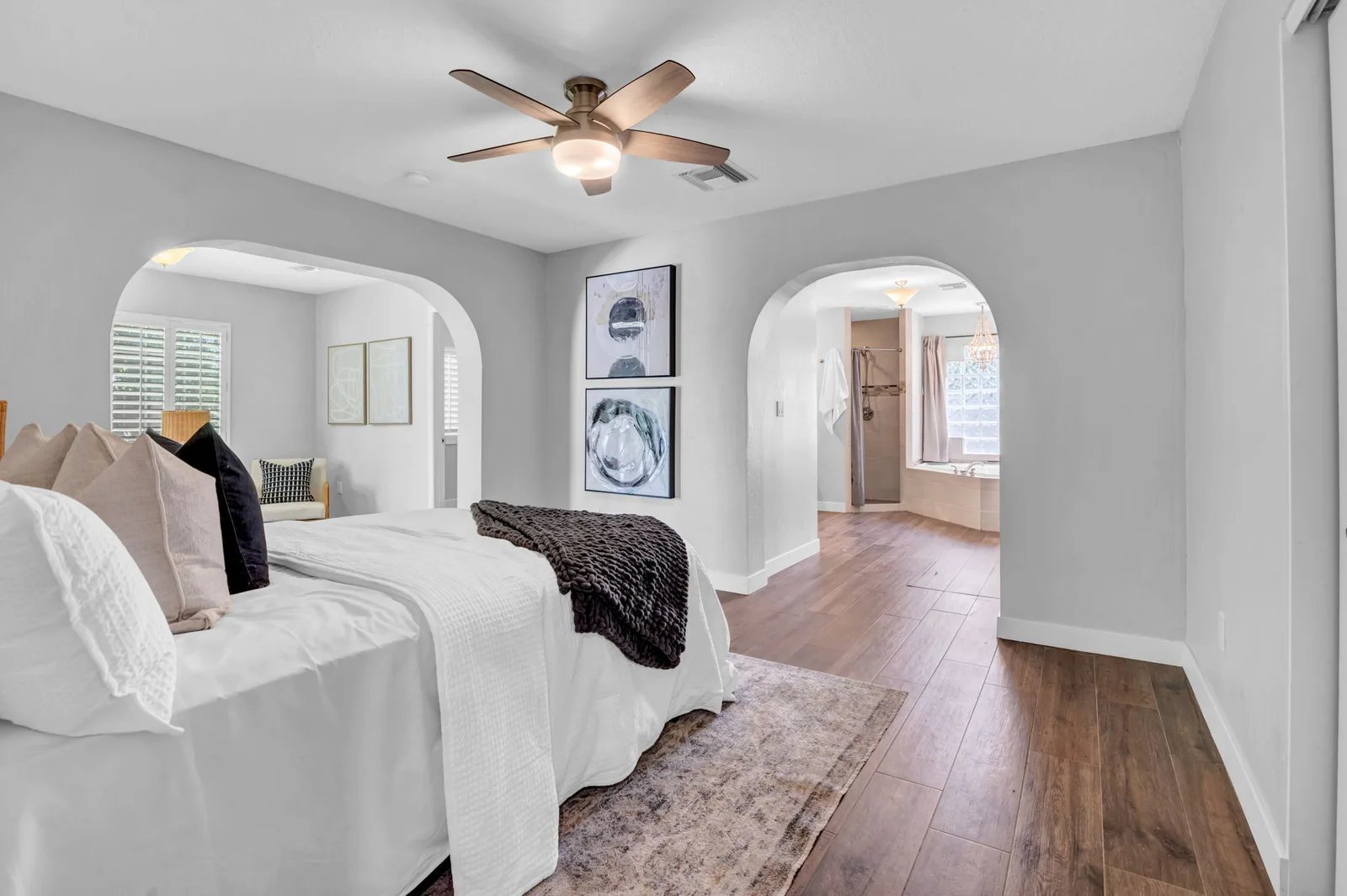 Bedroom with arched openings through to the bath and back yard light.