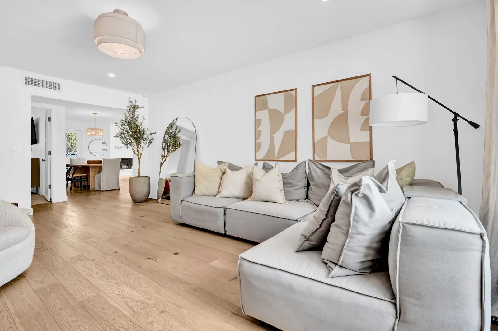 Sectional sofa and open living space with white oak floors.