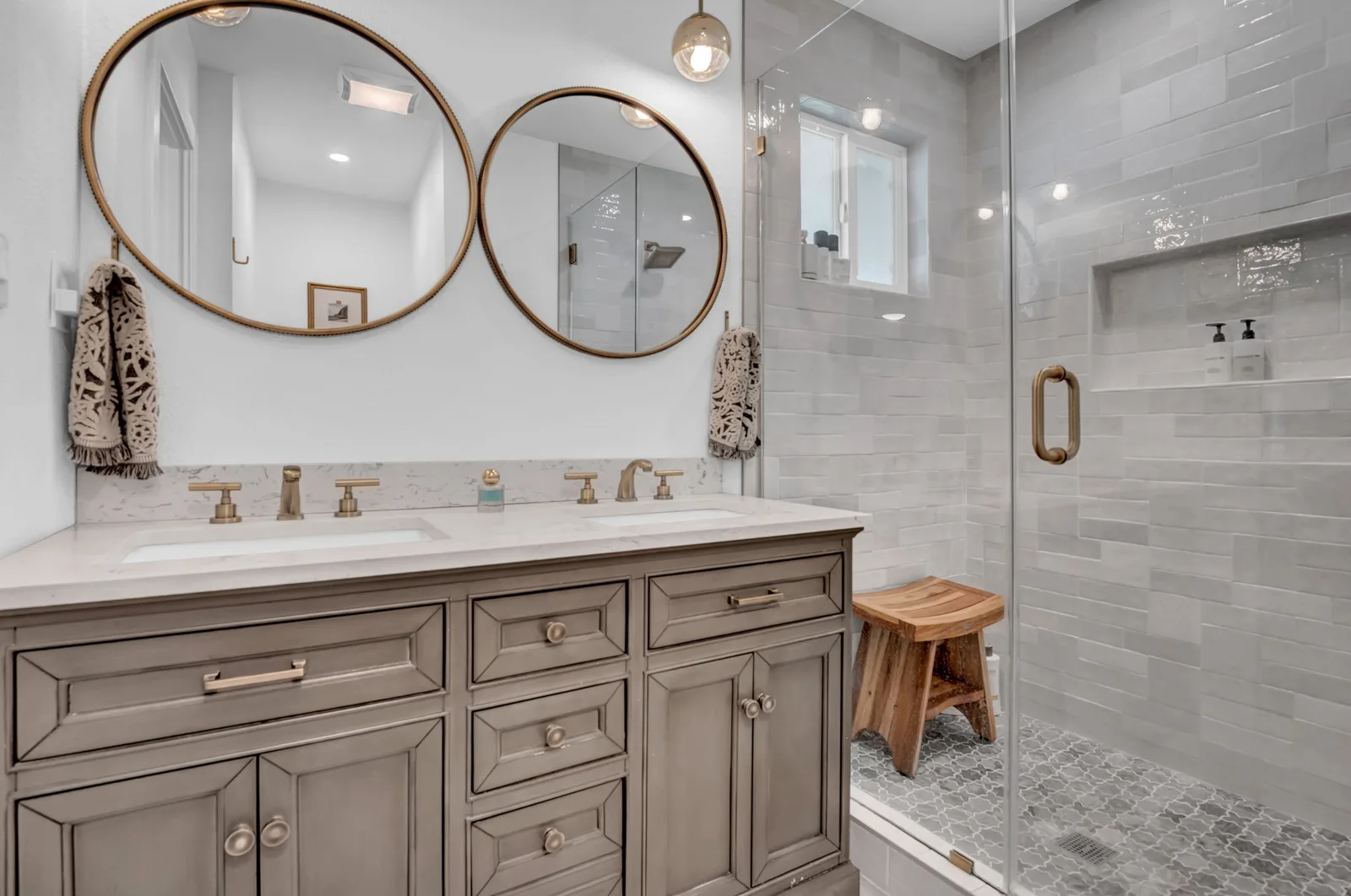 Primary bath with twin round mirrors, dual vanity and a walk-in shower.
