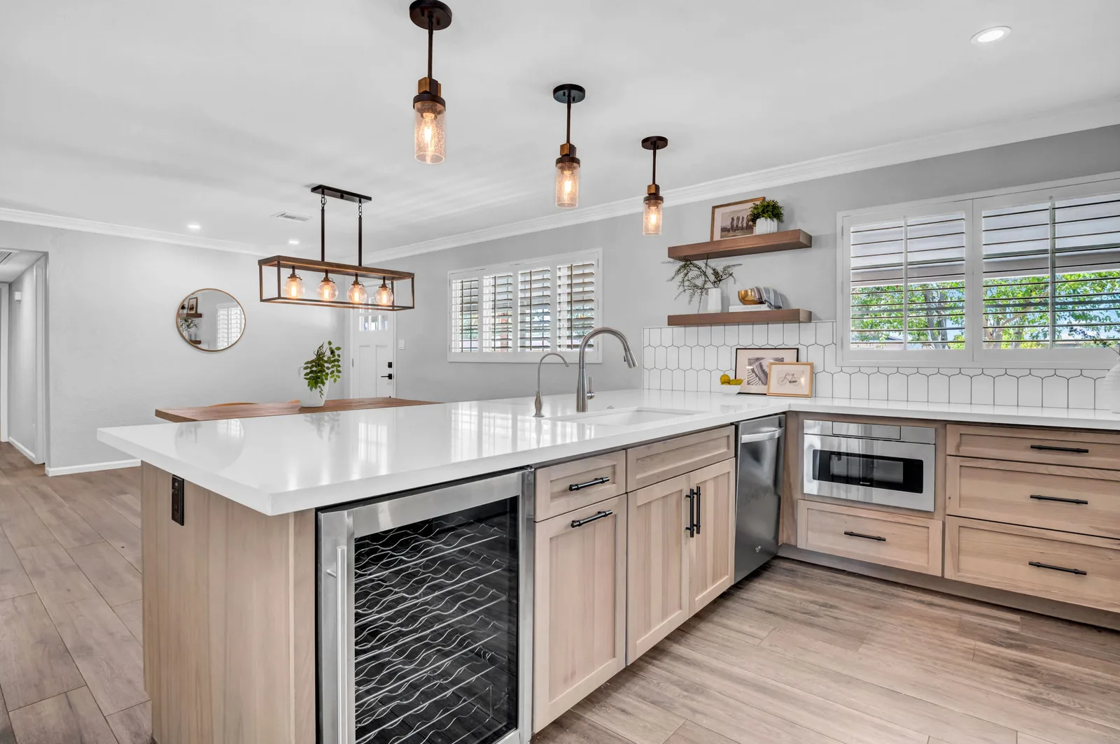 Kitchen with wine fridge, quartz island and warm wood cabinetry.